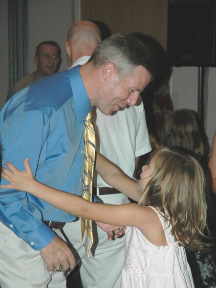 After the last dance of the evening, Lt. Col. Steven Burgh, 325th Operations Support Squadron commander, and his daughter embrace for a hug. The "Daddy Daughter Dance," which was the first event of its kind held at Tyndall, was hosted to bring Airmen together with their daughters for an evening to reconnect and create memories.
