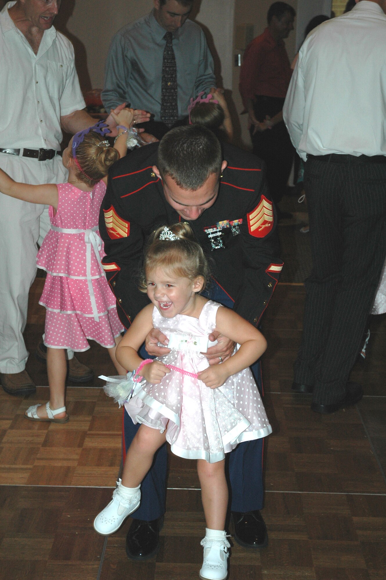 U.S. Marine Corps Sergeant Paul Rogers, local service recruiter, swings his daughter Julia to dance music playing during the "Daddy Daughter Dance" held at the Tyndall Heritage Club July 24. 