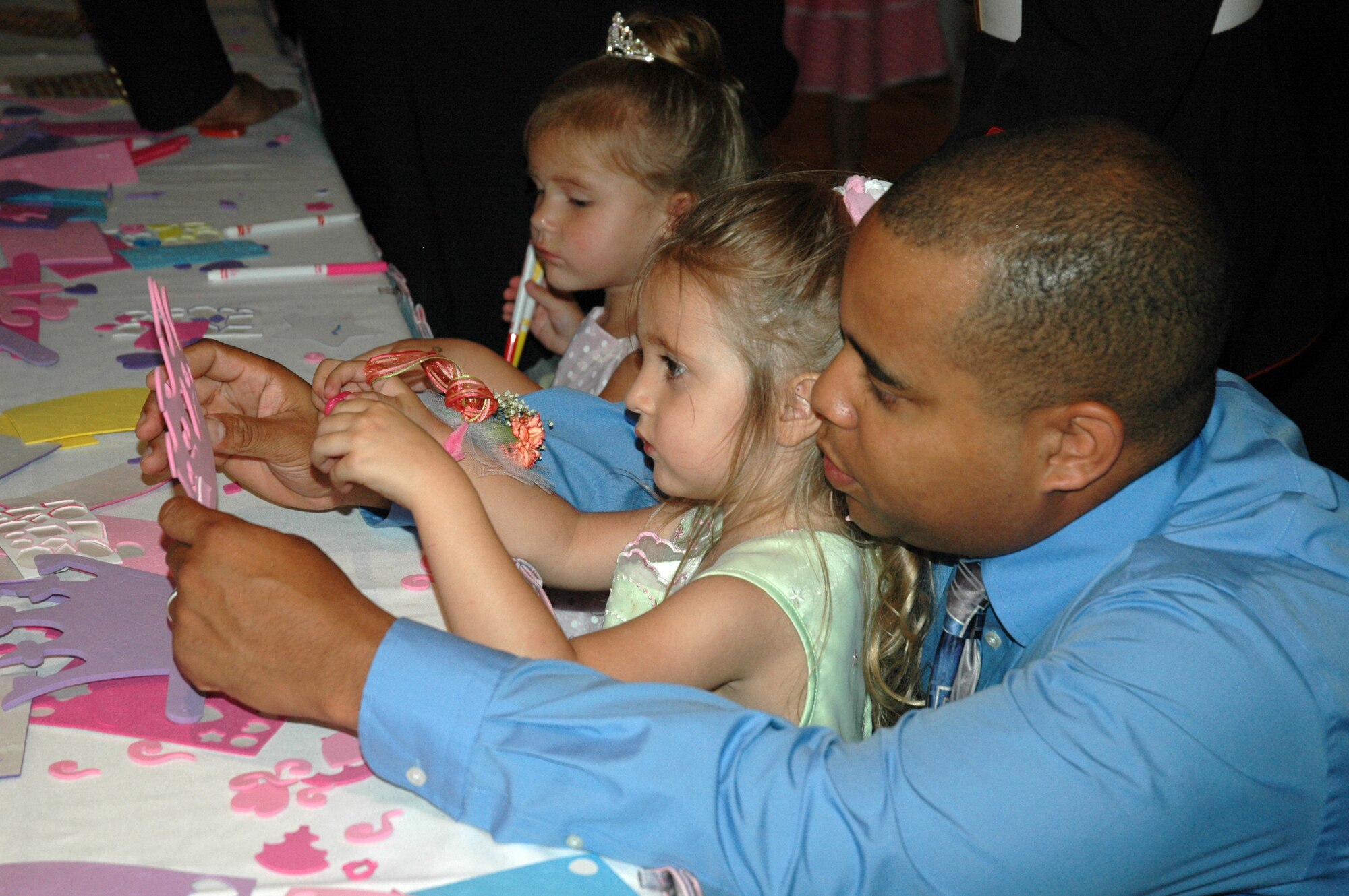 Staff Sgt. Richard Journagin of the 325th Maintenance Squadron and his daughter, Pristeena, work together to decorate a hand-made crown during the "Daddy Daughter Dance." The event, which was hosted by the 325th Services Squadron, joined Tyndall fathers and daughters together for a night of dancing and festivities.