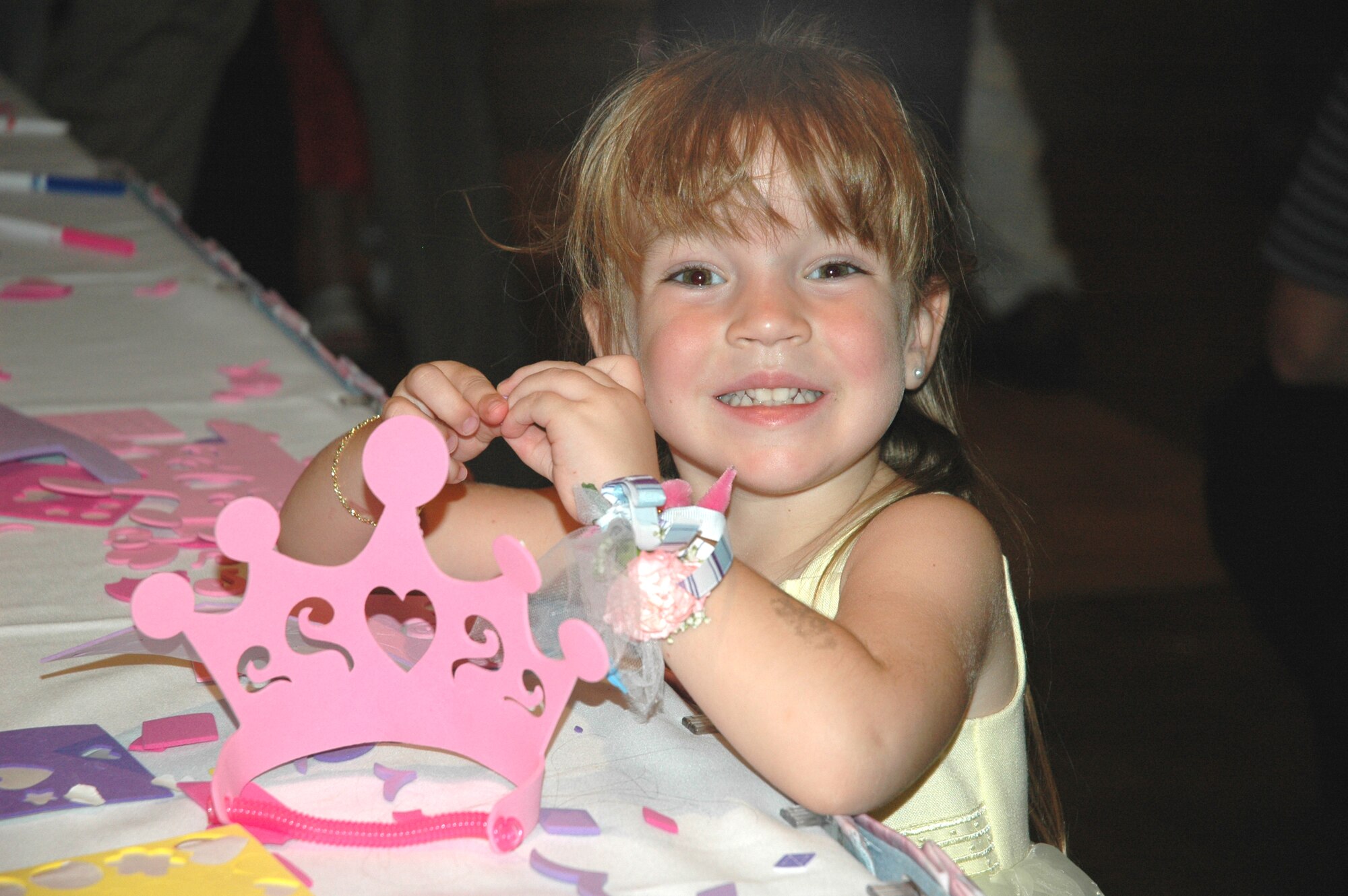 Scarlet Nation, daughter of Maj. Roman Nation of the 325th Medical Operations Squadron, stops to pose for a quick picture as she decorates a hand-made crown during the "Daddy Daughter Dance." The event, which was hosted by the 325th Services Squadron, joined Tyndall fathers and daughters together for a night of dancing and festivities.