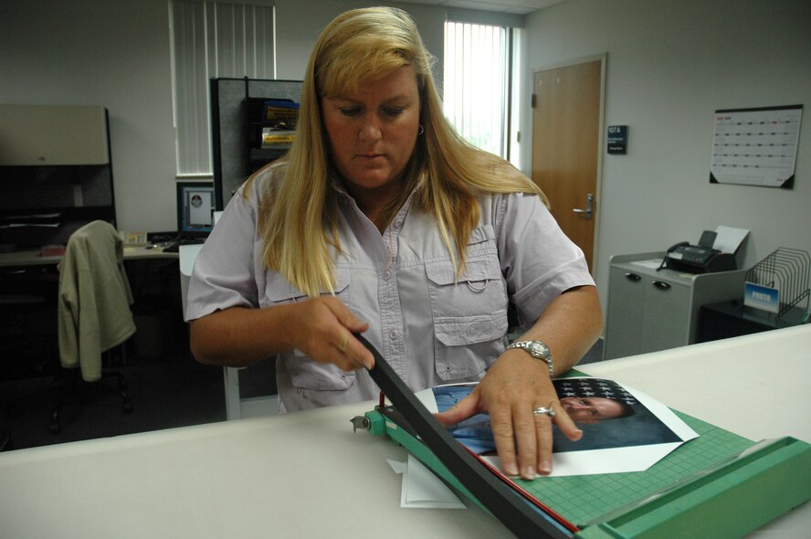 Lisa Norman, K-Mar Industries and Tyndall multimedia lead photographer and contractor, trims excess paper off an official photo at the multimedia lab here Thursday.  (U.S. Air Force photo/Staff Sgt. Timothy R. Capling)