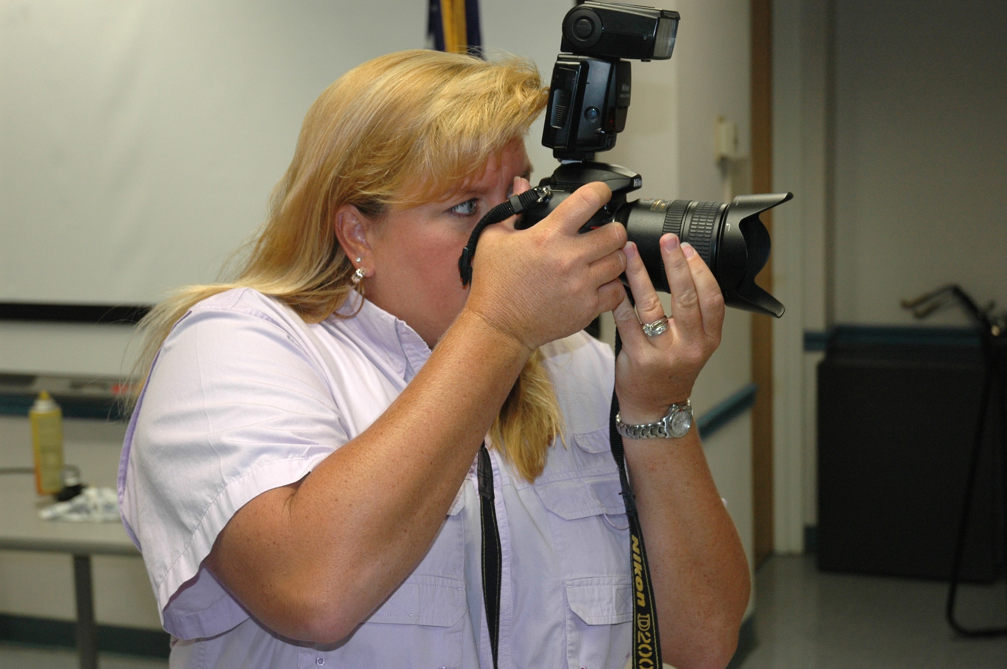 Lisa Norman, K-Mar Industries and Tyndall multimedia lead photographer and contractor, shoots a photograph of a group of 325th Security Forces Airmen for a deployment team shot Thursday. (U.S. Air Force photo/Staff Sgt. Timothy R. Capling)