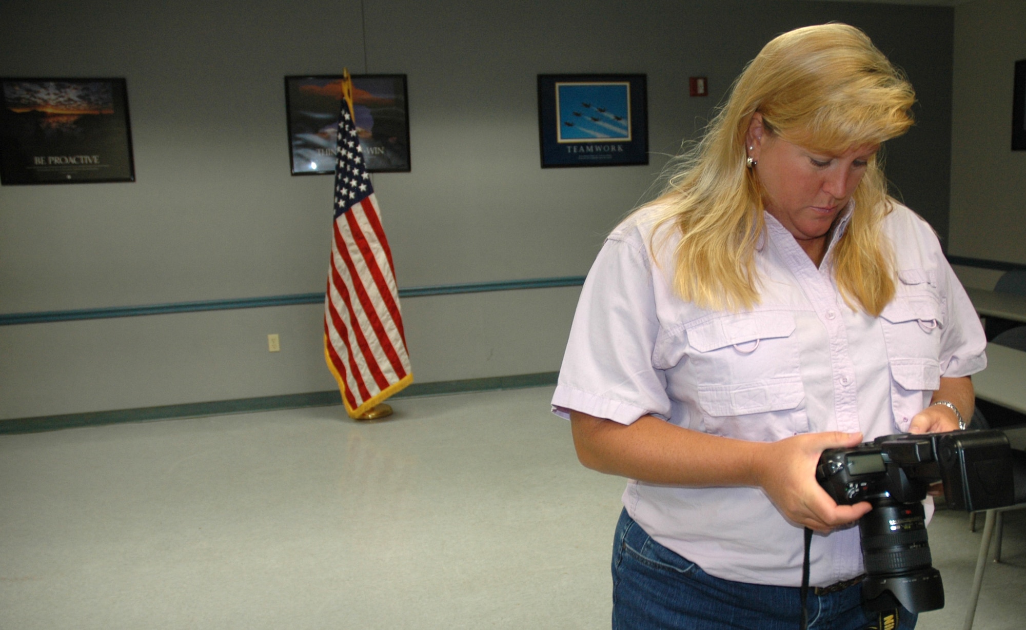 Lisa Norman, K-Mar Industries and Tyndall multimedia lead photographer and contractor, checks the settings on her camera prior to a photo shoot at the 325th Security Forces guard-mount room Thursday.  (U.S. Air Force photo/Staff Sgt. Timothy R. Capling)
