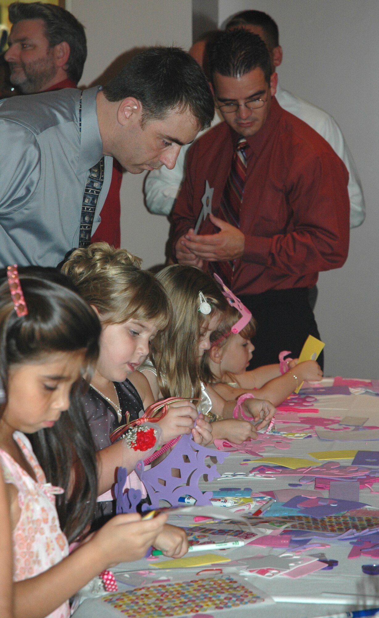 Daughters of Tyndall Airmen participated in arts-and-crafts projects during the "Daddy Daughter Dance" hosted at the Heritage Club July 24. Lt. Col. Joe Granducci, 325th Fighter Wing F-15 instructor pilot, checks in on his daughter as she decorates a hand-made crown, which were worn by the young ladies during the event.