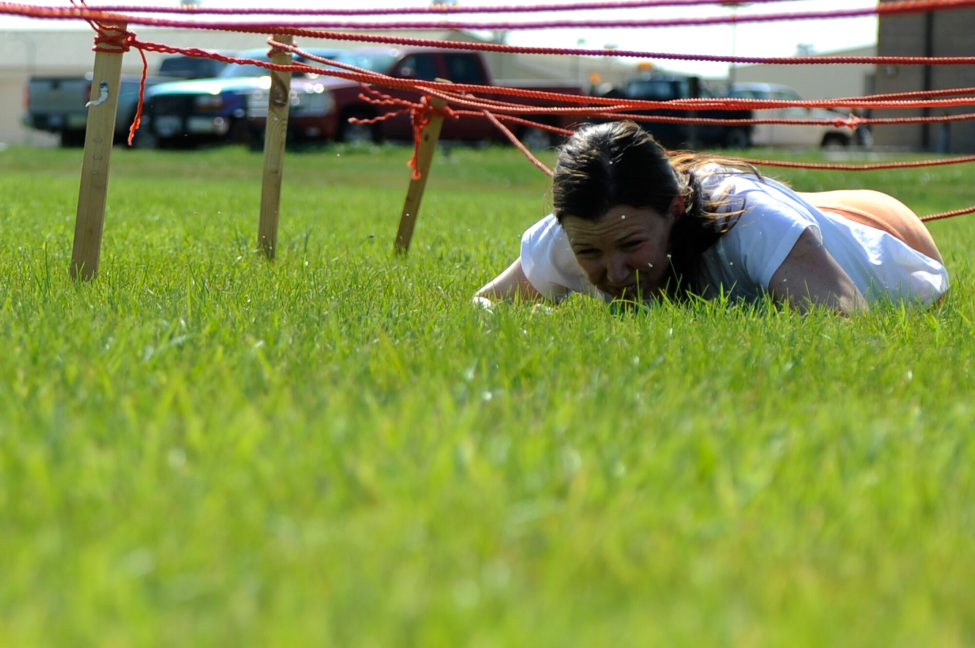 ELLSWORTH AIR FORCE BASE, S.D. -- Staff Sgt. Melissa Neild, 28th Operations Support Squadron flight administrator, low crawls through the first part of the obstacle course during the Iron Flight competition here July 31. Sergeant Neild helped her team win the competition by taking first place in the event. (U.S. Air Force photo/Airman Flynn)