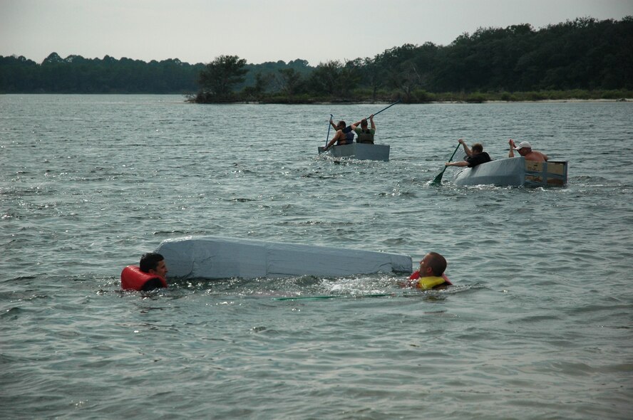 A team competing in the 2008 325th OSS Regatta Boat Race tips throwing two passengers overboard as other teams race on. The boat race was held July 25 at the Bonita Bay Recreation Center.
