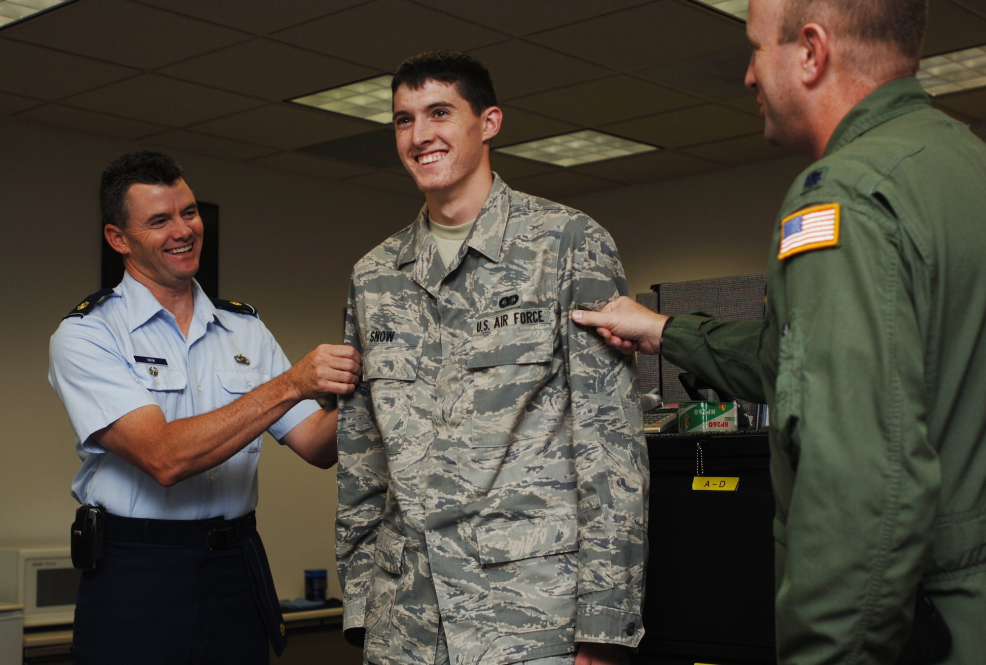 Elliott Snow gets promoted to the rank of airman first class during a ceremony at the 931st Military Personnel Flight office on July 31.  Helping tack on Airman Snow's new rank is his father, Maj. Mark Snow (on left), Director of Staff for the 22nd Air Refueling Wing at McConnell Air Force Base, Kan.  Adding rank insignia to Airman Snow's other sleeve is Lt. Col. Chris Amend, 931st Operations Support Flight commander.  Airman Snow is an information manager assigned to the 931st Aerospace Medicine Flight currently training with the 931st Communication and Information Systems Flight. (U.S. Air Force photo/Tech. Sgt. Jason Schaap)