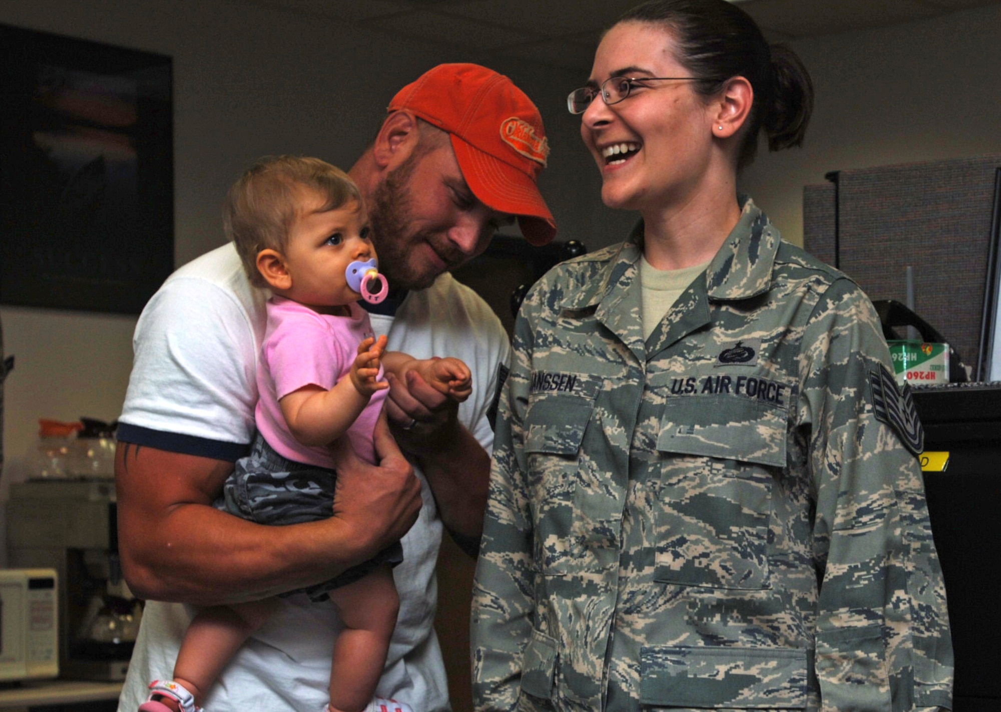 Joel Janssen, husband of just-promoted Tech. Sgt. Amber Janssen, and their 10-month old daughter, Emily, help tack on new rank to Amber's uniform during a promotion ceremony at the 931st Military Personnel Flight office on July 31.  Sergeant Janssen is in charge of the MPF's relocations section.  Joel also serves with the 931st Air Refueling Group as a staff sergeant assigned to the 931st Aircraft Maintenance Squadron. (U.S. Air Force photo/Tech. Sgt. Jason Schaap)