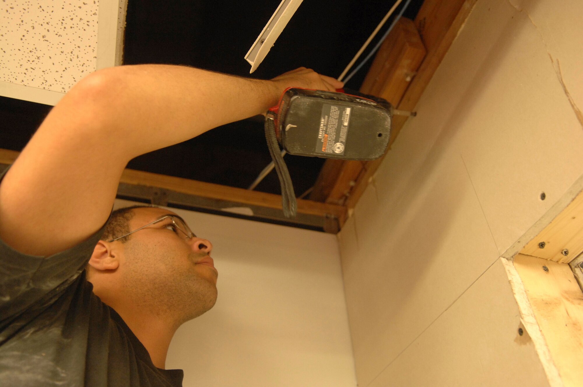 SHAW AIR FORCE BASE, S.C.-- Senior Airman Michael Sheppard, project team member, secures sheetrock to a newly built wall as part of the Hangar 1200 renovation July 24. Col. James Post, 20th Fighter Wing commander, made the decision to turn a portion of Hangar 1200 into a ceremonial center in August, 2007, and the renovations began in March, 2008. (U.S. Air Force photo/Staff Sgt. Nathan Bevier)