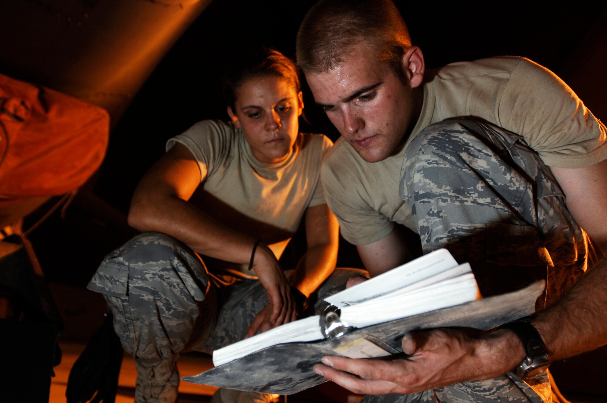 JOINT BASE BALAD, Iraq -- Staff Sgt. Prentiss Hyde (right) reviews a technical order with Airman 1st Class Christeen Angelaitis while the Airmen install a radar rack into an F-16 Fighting Falcon here July 31. The radar powers the F-16's radar package, allowing the pilot to detect aircraft and guide bombs onto targets. Sergeant Hyde is an avionics craftsman, and Airman Angelaitis is an avionics journeyman. Both Airmen are assigned to the 77th Expeditionary Fighter Squadron here and are deployed from Shaw Air Force Base, S.C. (U.S. Air Force photo/Airman 1st Class Jason Epley)
