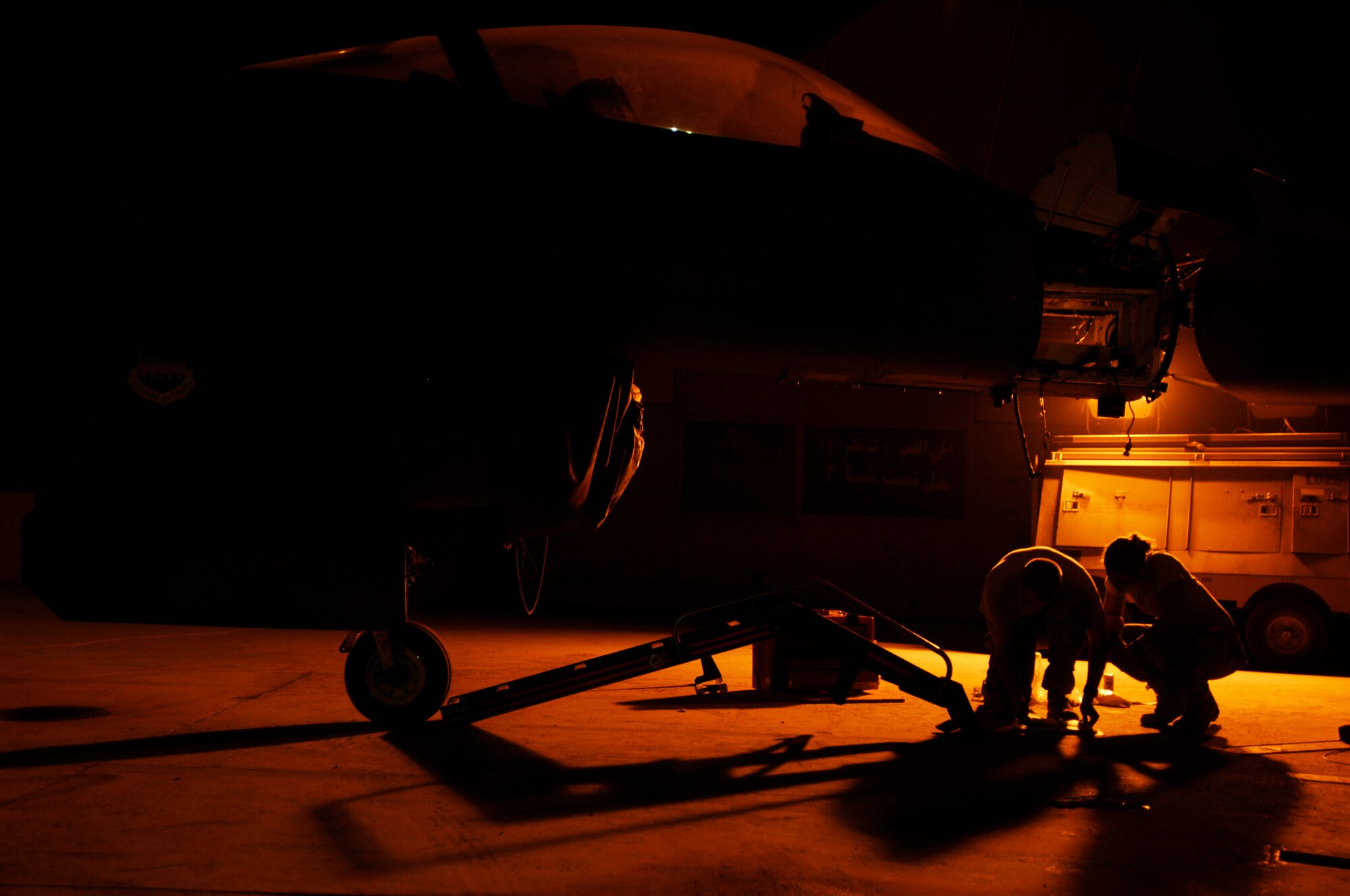JOINT BASE BALAD, Iraq -- Staff Sgt. Prentiss Hyde (left) and Airman 1st Class Christeen Angelaitis review a technical order while installing a radar rack into an F-16 Fighting Falcon here July 31. The radar rack powers the F-16's radar package, allowing the pilot to detect aircraft and guide bombs onto targets. Sergeant Hyde is an avionics craftsman, and Airman Angelaitis is an avionics journeyman. Both Airmen are assigned to the 77th Expeditionary Fighter Squadron here and are deployed from Shaw Air Force Base, S.C. (U.S. Air Force photo/Airman 1st Class Jason Epley)