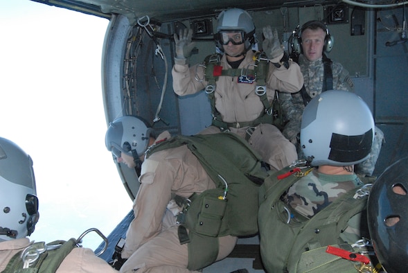 Master Sgt. Jason Colon, 18th Weather Squadron first sergeant, gives a signal to four Airmen waiting to execute a High Altitude, Low Opening jump over Luzon Drop Zone July 16. Sergeant Colon served as jumpmaster and was giving non-verbal cues to his jumpers due to the noise made by the UH-60 Black Hawk helicopter. (U.S. Air Force Photo by 2nd Lt. Chris Hoyler)