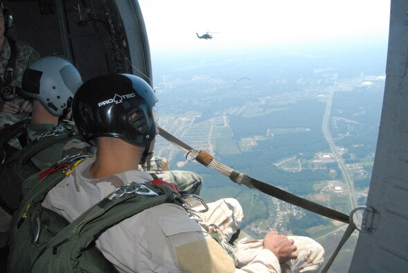 Airmen from the 93rd Air Ground Operations Wing look out the side door of a UH-60 Black Hawk helicopter July 16 before executing their High Altitude, Low Opening jump over Luzon Drop Zone at Fort Bragg. In the background is a second Black Hawk with members from the 93rd AGOW.  (U.S. Air Force Photo by 2nd Lt. Chris Hoyler)