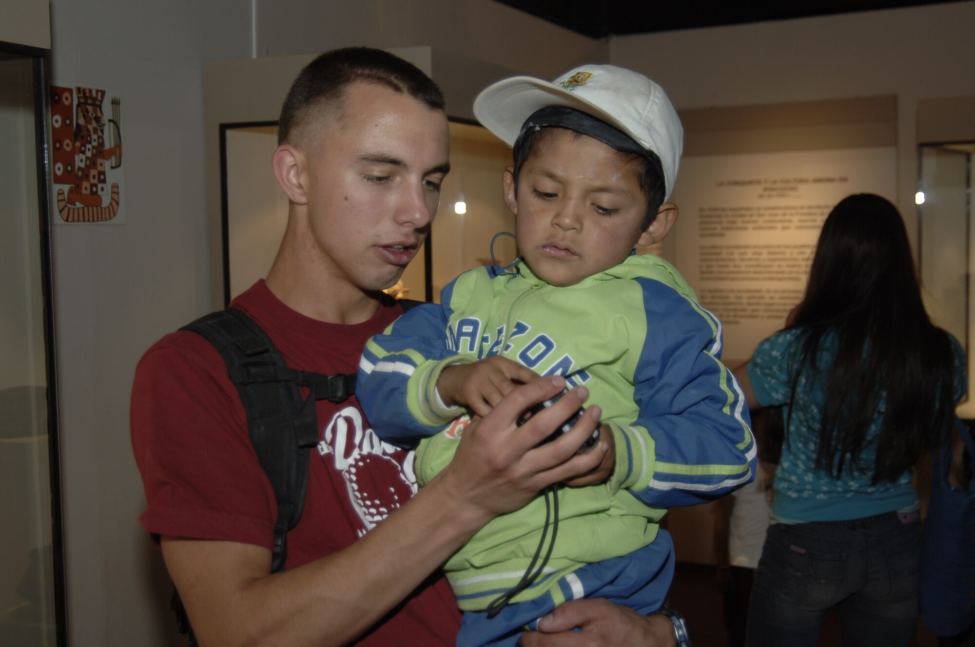 Airman 1st Class Jason Holmlund, Task Force New Horizons vehicle maintainer, shows a Peruvian child his digital camera at a Ayacucho museum, July 25.  Task force members treated children at the school on post to a day at the museum and school as part of New Horizons community outreach. (U.S. Air Force photo by Capt. David Tomiyama)