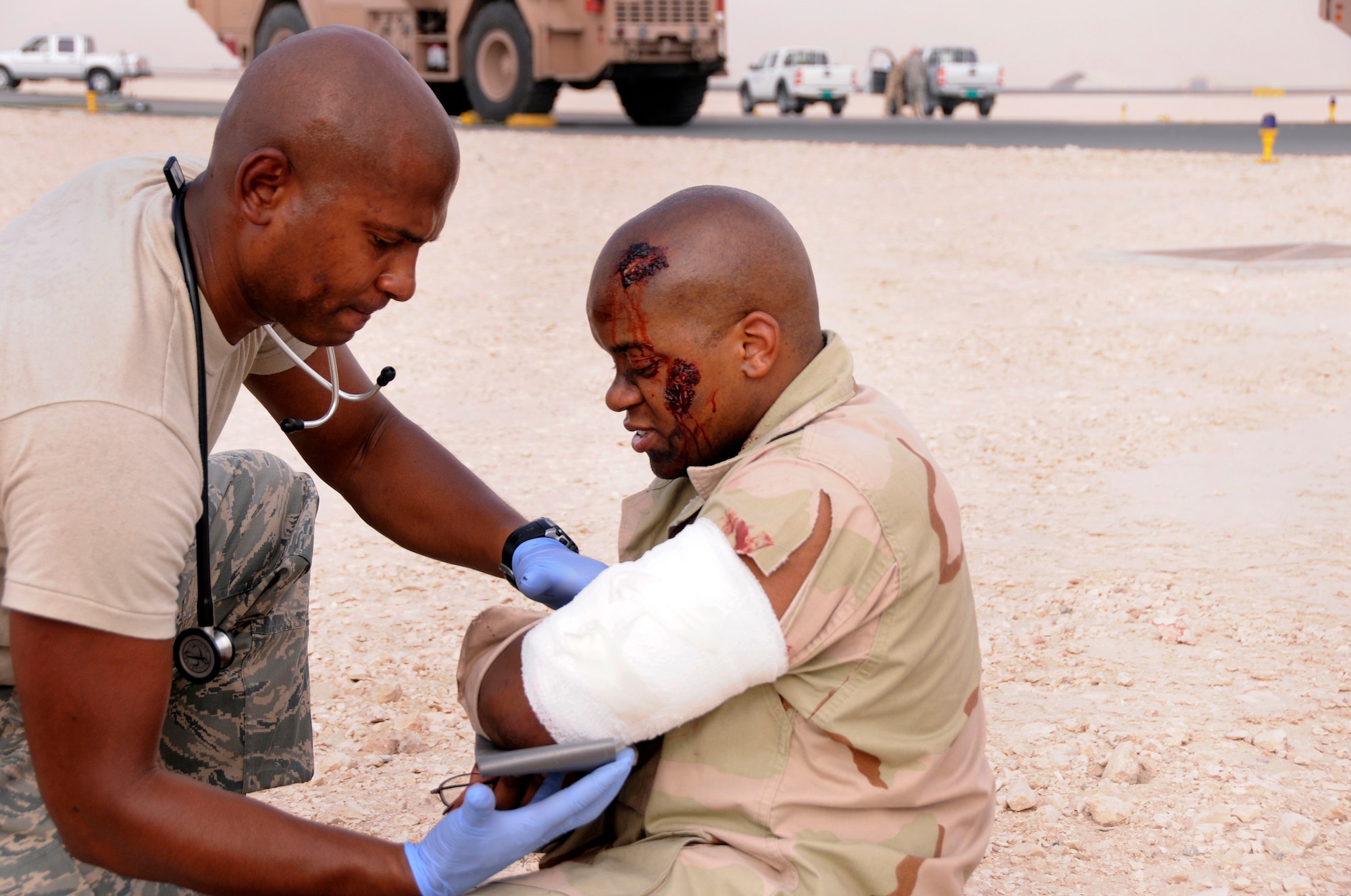 Tech. Sgt. Enoch Daniels, 340th Expeditionary Air Refueling Squadron independent medical duty technician, fits a splint onto the simulated injured arm of Senior Airman Jonathan Shiels during a Major Accident Response Exercise in Southwest Asia July 28. Airman Shiels, 379th Expeditionary Force Support Squadron, role plays an accident victim to help test emergency response operations, accountability of personnel, mortuary services, and higher headquarters reporting procedures.  Sergeant Daniels is deployed from MacDill Air Force Base, Fla., and Airman Shiels is deployed from Davis-Monthan Air Force Base, Ariz. (U.S. Air Force photo by Tech. Sgt. Michael Boquette)