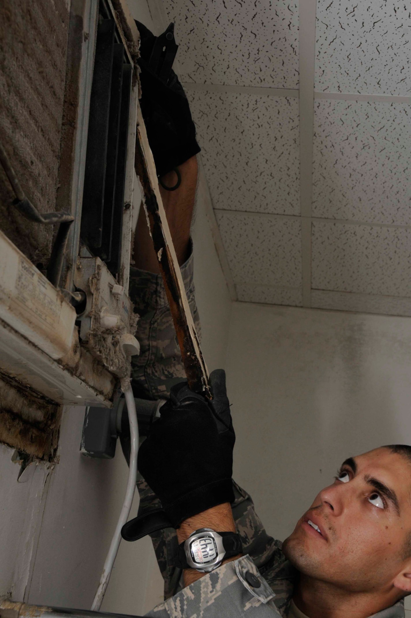 Staff Sgt. Cesar Alvarado, 379th Expeditionary Civil Engineer Squadron, removes the trim around an inoperable air conditioning unit in a cadillac July 30 in Southwest Asia. Cadillacs are bathroom facilities for deployed military members and its Sergeant Alvarado’s job to perform daily maintenance on it. Sergeant Alvarado is a structural journeyman deployed from Eglin Air Force Base, Fla. (U.S. Photo/Staff Sgt. Darnell T. Cannady)