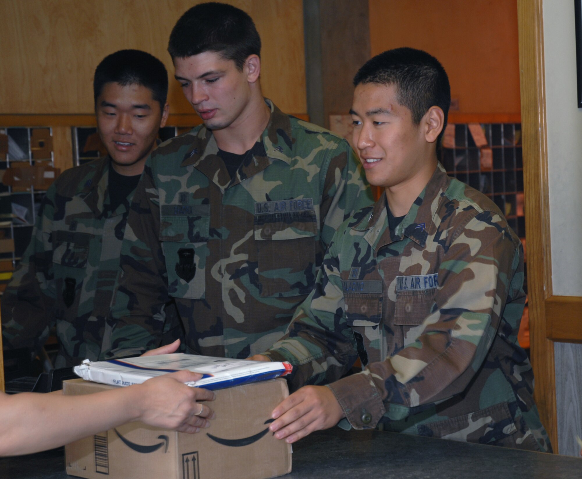 Cadet 2nd Class Alexander Paladino, Air Force Academy cadet, hands a customer their packages while working the front window of the post office.  Operation Air Force gives academy cadets an opportunity to visit Air Force bases during the summer to learn how an operational base functions. (U.S. Air Force photo by Airman 1st Class Jessica Donnelly)