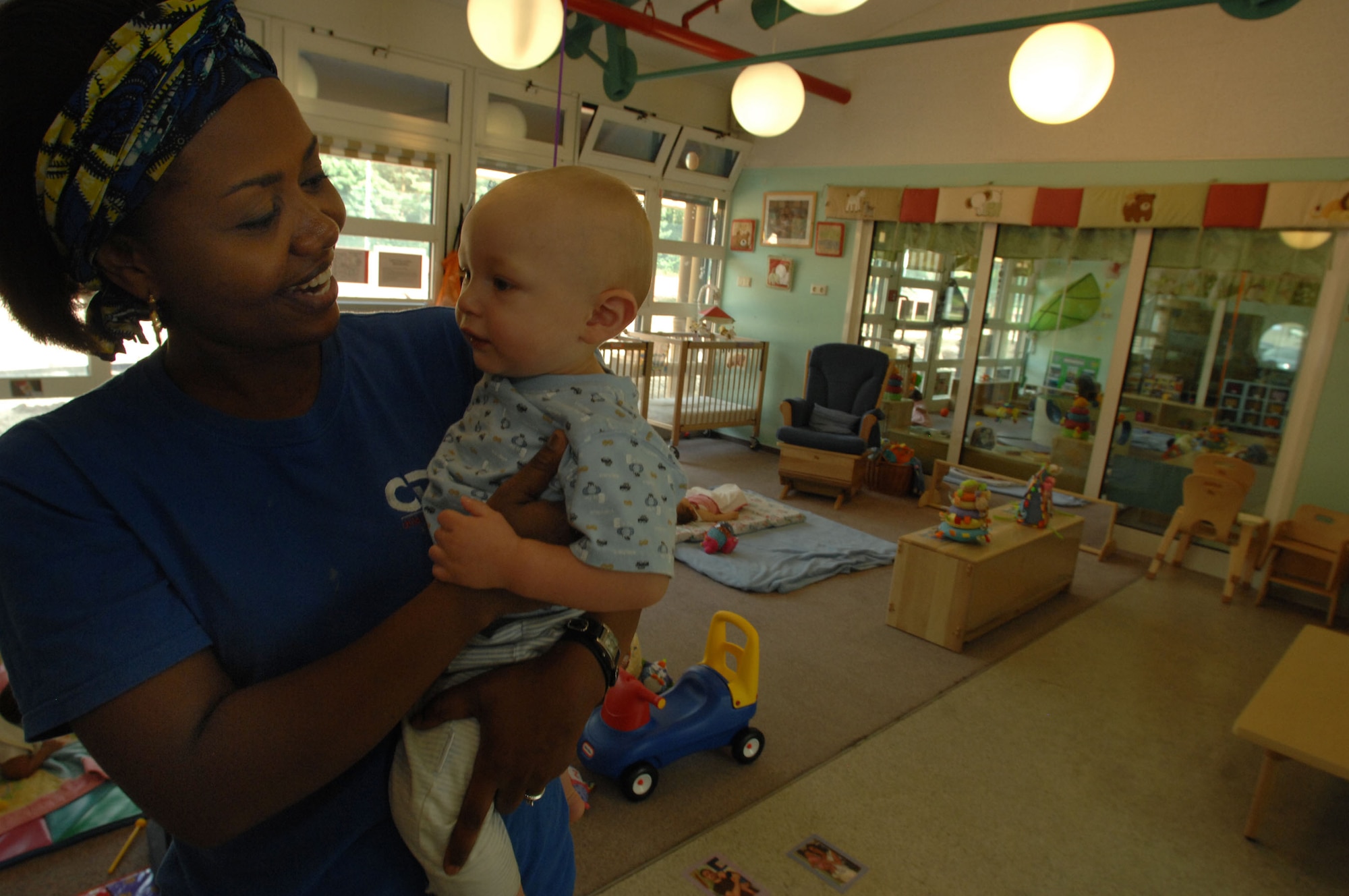Nadine Mvumbi, child development program assistant, sings a song to one-year-old Christian Bressler at the Vogelweh Child Development Center, July 31, 2008.  There are three CDC's located in the Kaiserslautern Military Community: Ramstein, Sembach and Vogelweh. (U.S. Air Force photo by Senior Airman Amber Bressler)(Released)