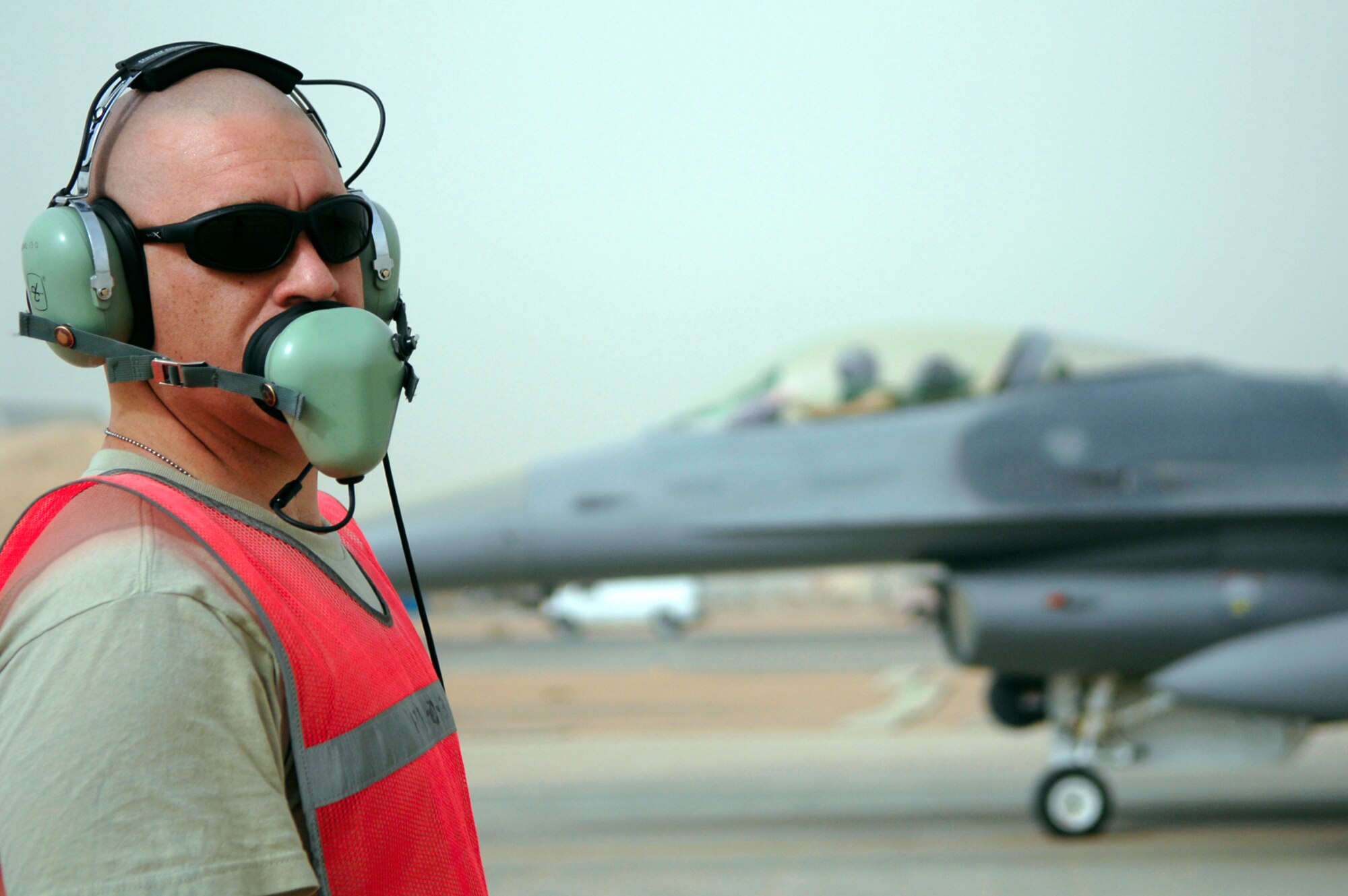JOINT BASE BALAD, Iraq -- Tech Sgt. Jason Owens talks to fighter pilots during arming of an F-16 Fighting Falcon here July 8. When the Syracuse, N.Y., Air National Guard unit returns from its current deployment to Joint Base Balad, it will become the first Air National Guard unit in the country to adopt an MQ-9 Reaper unmanned aerial system mission. Sergeant Owens, a weapons specialist with the 332nd Expeditionary Fighter Squadron, is deployed from Hancock Field Air National Guard Base in Syracuse, N.Y. (U.S. Air Force photo/Senior Airman Julianne Showalter)