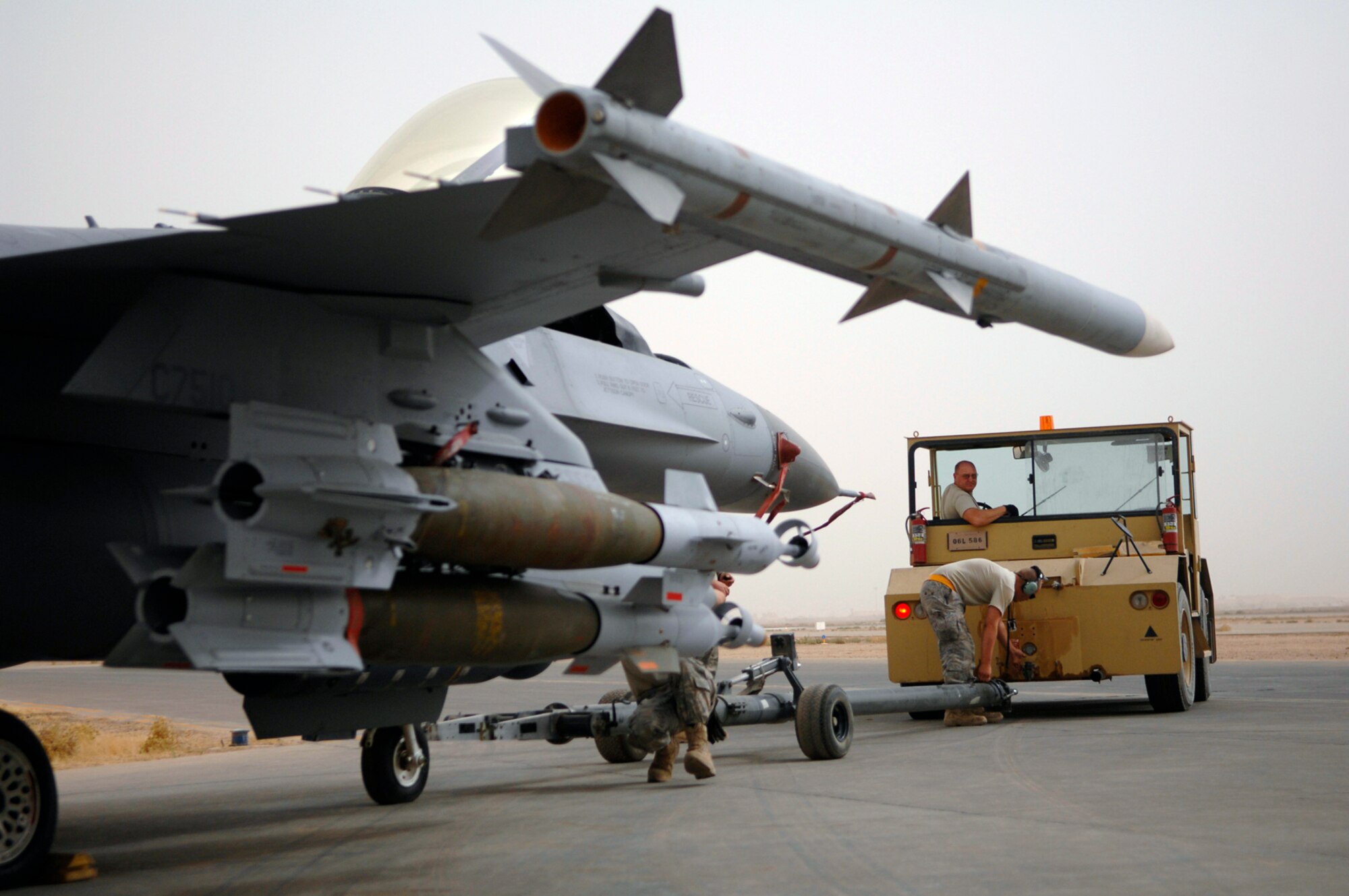 JOINT BASE BALAD, Iraq -- Airmen assigned to the 332nd Expeditionary Fighter Squadron here disconnect an F-16 Fighting Falcon from a tow truck in preparation for a combat mission over Iraq July 8. The Airmen are deployed from the 174th Fighter Wing at Hancock Field Air National Guard Base, Syracuse, N.Y. The 174th FW will become the first Air National Guard unit to adopt an MQ-9 Reaper unmanned aerial system mission when it returns from its deployment to Iraq. (U.S. Air Force photo/Senior Airman Julianne Showalter)