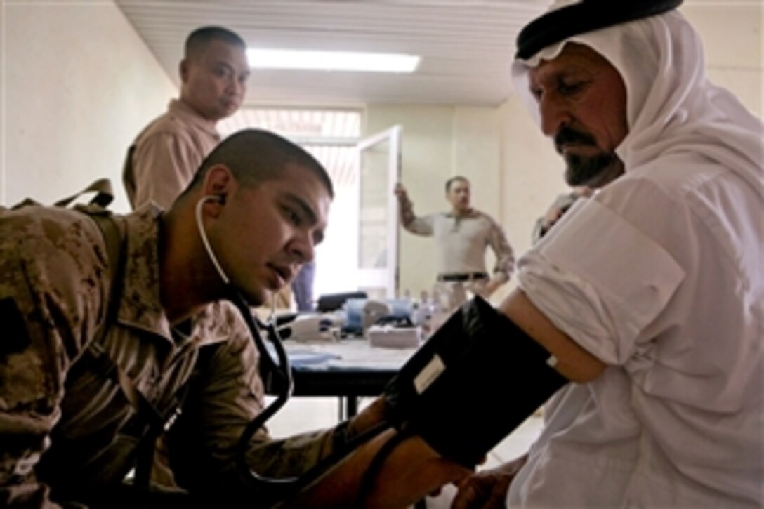 U.S. Navy Petty Officer 2nd Class Reyes Camacho checks the blood pressure of an Iraqi patient in the triage area of a clinic in Akashat, Iraq, July 23, 2008. Camacho is a hospital corpsman assigned to Marine Wing Support Squadron 172.