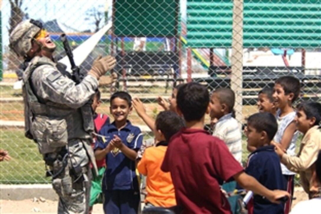 U.S. Army Sgt. Thomas Dwyer laughs with Iraqi children while on a patrol in the Sadr City district of Baghdad, Iraq, July 28, 2008. Dwyer is a military policeman assigned to the 4th Infantry Division's 3rd Brigade Combat Team. 