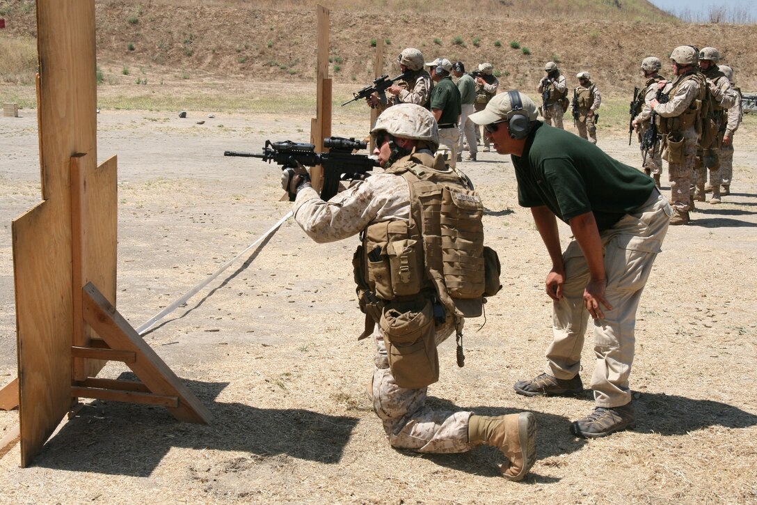 Capt. Jonathan Morgenstein, an officer with 2nd Battalion, 25th Marine Regiment's military transition team, practices shooting from the kneeling position by a simulated window during a small arms live-fire range Aug. 1 at Camp Pendleton, Calif.  The MiTT is headed for a seven-month deployment to Iraq in the fall.