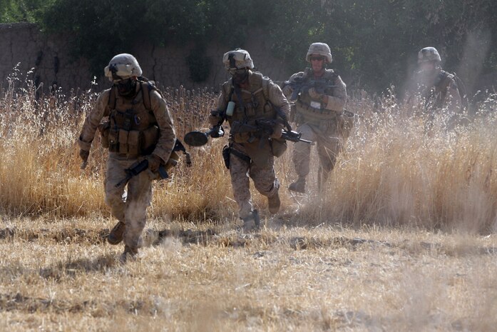Combat engineers of Task Force 2nd Battalion, 7th Marine Regiment, 1st Marine Division, run back to a safe position after placing a wall charge to breach a Taliban headquarters. ::r::::n::::r::::n::