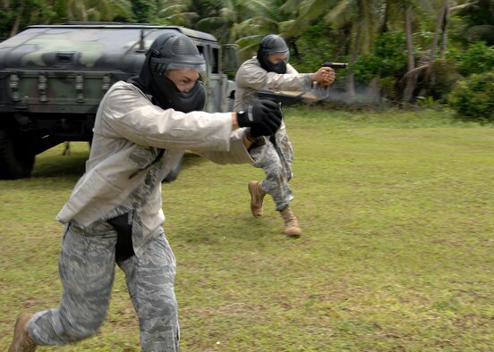 Staff Sgt. Daniel Gonzalez from Kadena Air Base, Japan and Staff Sgt. Robert Bishop from Misawa Air Base, Japan participate in  a live fire scenario during the Commando Warrior Simuntions training exercise July 30 at Andersen Air Force Base, Guam. M-9 and M-4 Simunition configured training weapons and colored FX rounds were used during the training course. Security Forces airmen from across  the Pacific Air Forces came together to perform the training hosted by the 736th SFS. (U.S. Air Force photo by Airman 1st Class Nichelle Griffiths)