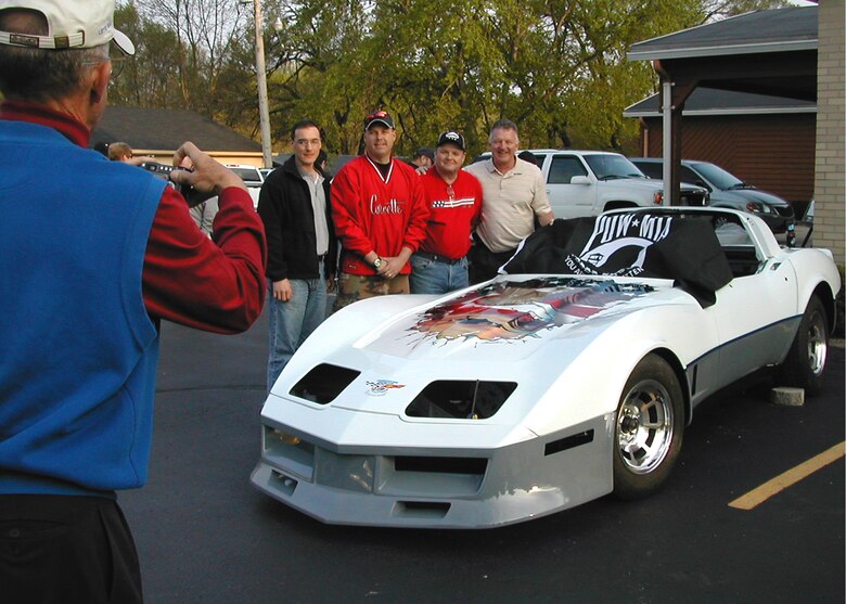 WRIGHT-PATTERSON AFB, Ohio - The restoration team of a 1980 Corvette tribute car pose for a group photograph. The restored Corvette is a tribute to Vietnam POW's and the plane that brought them home.(Pictured Left to Right-Maj. Gen. Edward Mechenbier(taking a photo), Capt. Richard Lopez, Maj. Richard Webster, Tech Sgt. Eugene Mullen, Master Sgt. Harold Stinnette. (courtesy photo)