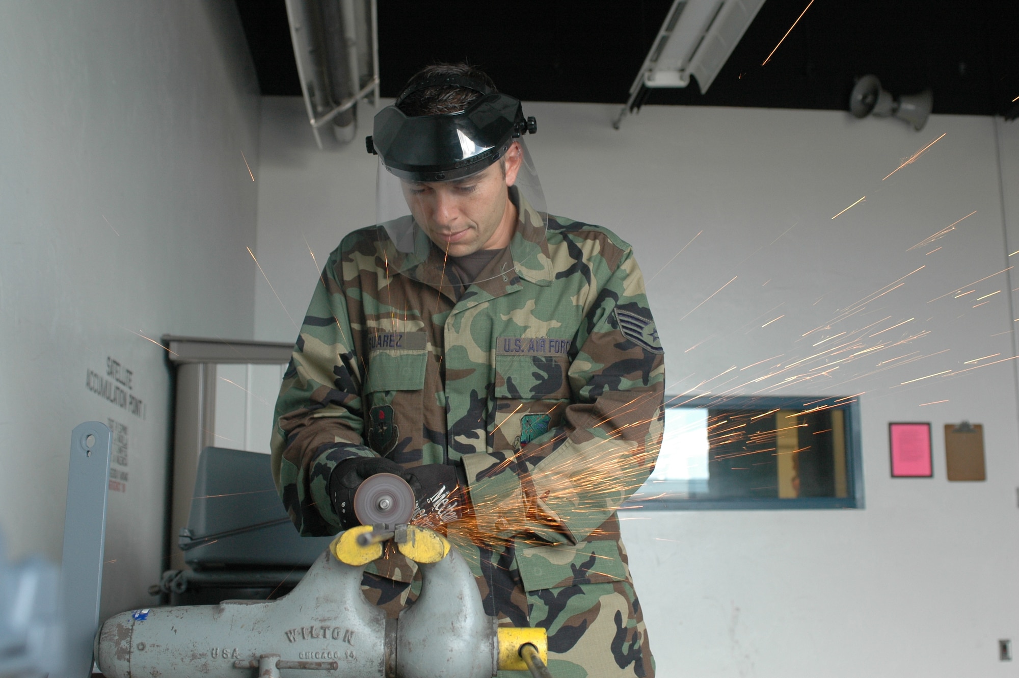 Staff Sgt. Louis Suarez, power support systems mechanic, grinds a piece of 3/8 inch round stock to fabricate a replacement brake rod for a C-10C air conditioner. The unit was damaged during a deployment to Edwards AFB, Calif. By fabricating parts like this one instead of ordering replacement parts, the AGE shop is able to maintain a 95 percent in-commission rate for 427 pieces of equipment. (Air National Guard photo by Staff Sgt. Jordan Jones)