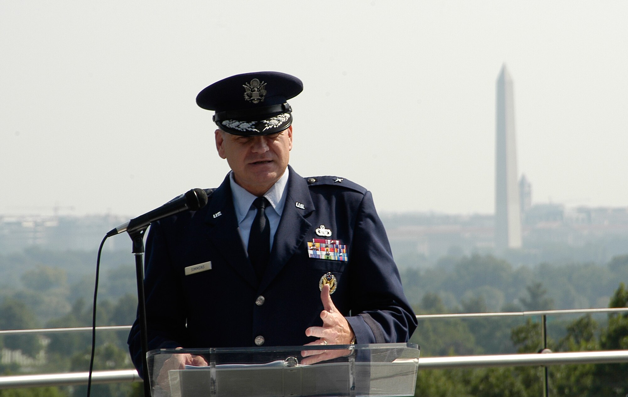 Brigadier General Dana Simmons, Air Force Office of Special Investigations Commander, delivers a speech celebrating 60 years of proud service from the men and women of AFOSI Aug.1 at the Air Force Memorial. Behind him in the distance is the Washington Momument. (U.S. Air Force photo/Tech. Sgt. John Jung)