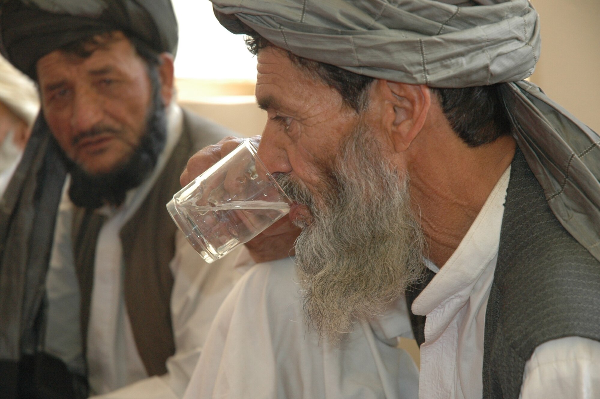 QALAT, Afghanistan -- A Shajoy village elder sips purified water after Zabul Provincial Reconstruction Team medical personnel introduced a new water sanitation process called hypochlorite generation, July 31. The team chose Shajoy to test run the process, which (after initial costs) creates clean drinking water for 300 families or 4-5,000 people at just $5 per month. (U.S. Air Force photo by Capt. Jean Duggan) 