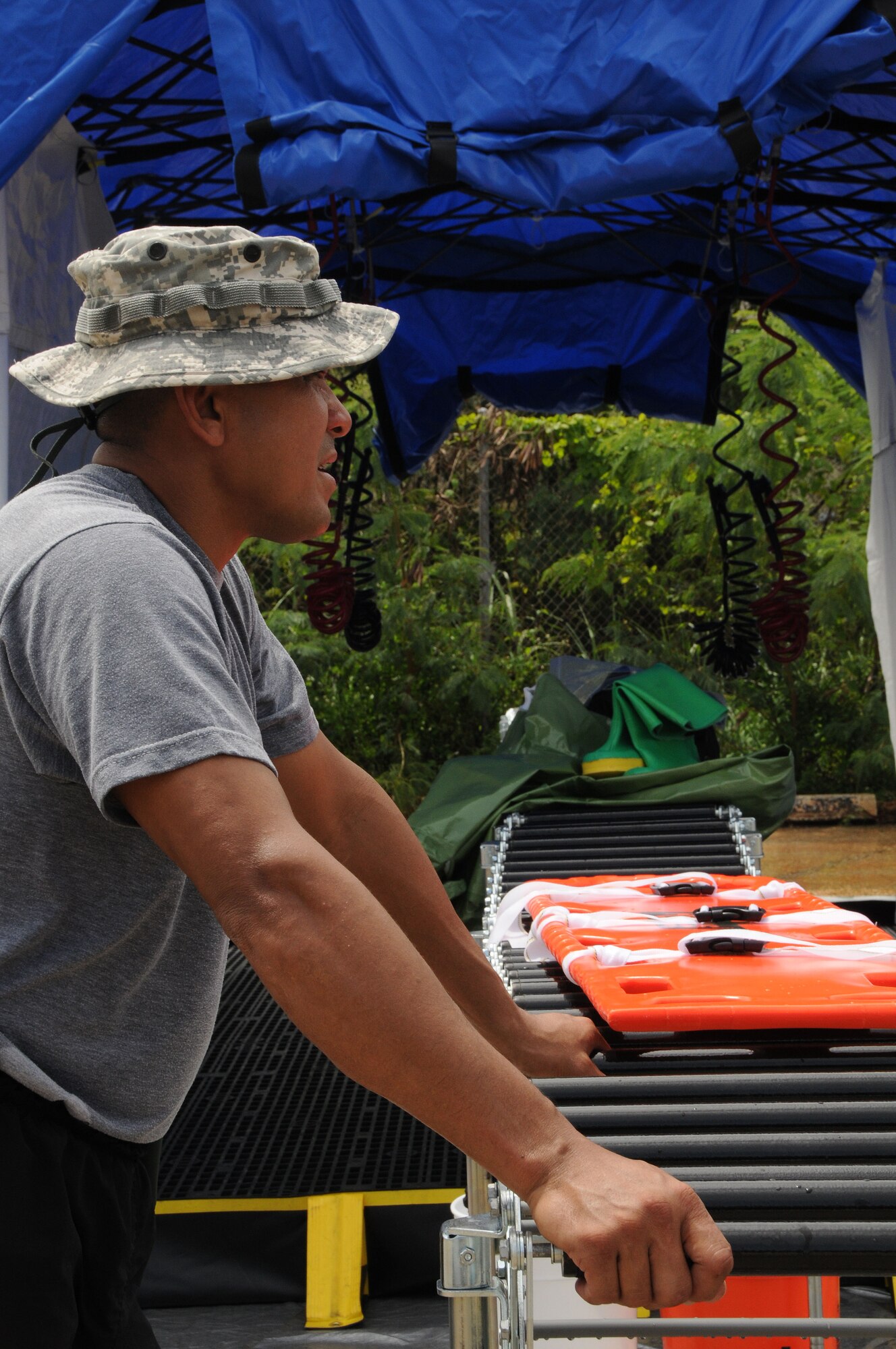 ANDERSEN AIR FORCE BASE, Guam - U.S. Army National Guard Sgt. 1st Class Randy Angoco of the 94th Civil Support Team relaxes after setting up a tent which houses a three-lane mass casualty decontamination system at a DoD no-notice mass causality airport disaster workshop held at Won Pat International Airport July 31. The decontamination system had two ambulatory lanes inside the tent - one for females and one for males; a third station was outside for non-ambulatory patients. Using the system, response personnel can decontaminate approximately 200 people per hour. (U.S. Air Force photo by Airman 1st Class Courtney Witt)