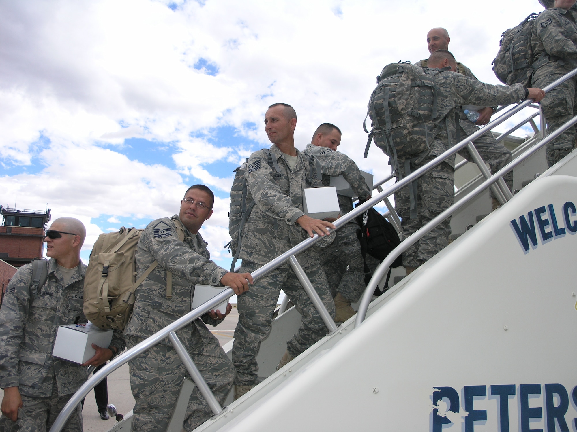 Master Sgt. Issac Lopez and Tech. Sgt. Glen Guba along with many members of the 302nd Security Forces board a Southwest Airlines flight that will transport them overseas to support ongoing operations in Iraq.  The group also included members from the 310th Space Wing and 710th Space Group Security Forces.  (U.S. Air Force photo/Tech. Sgt. David D. Morton)
