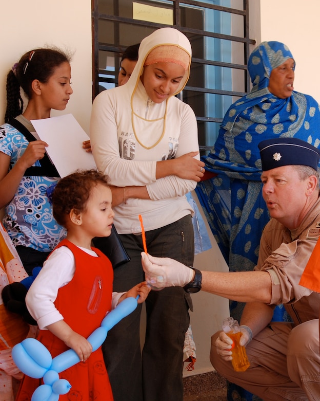 Lt. Col. Paul Byrd, humanitarian civil assistance commander with the 151st Expeditionary Medical Group, shows a young moroccan girl how to blow bubbles while she waits to be seen at a temporary clinic in July during African Lion 2008. (USAF photo by Master Sgt. Sterling Poulson)