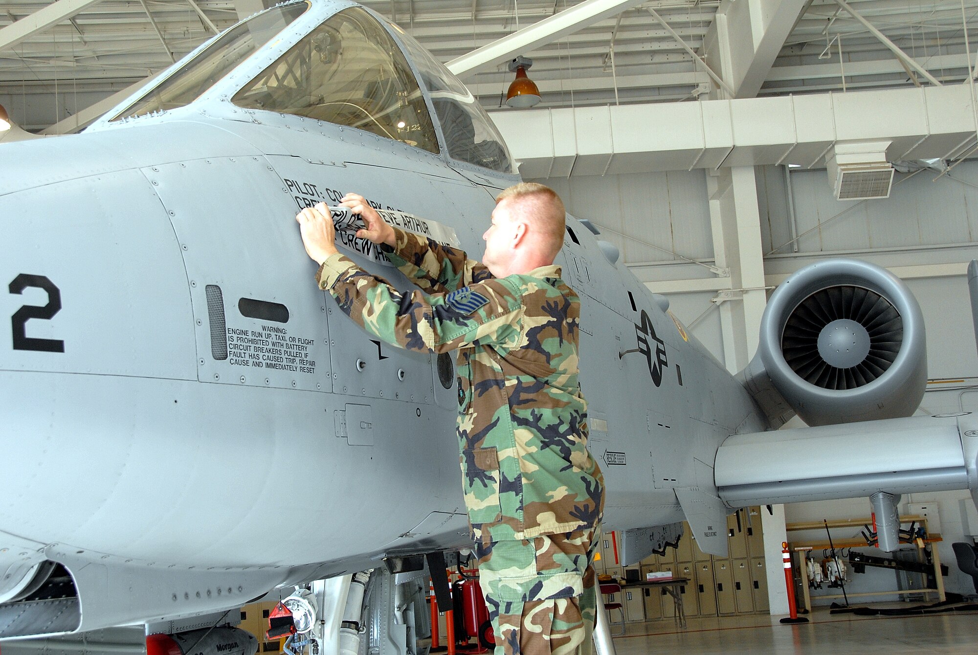 Tech. Sgt. Jim McGilton, a 442nd Fighter Wing crew chief, removes a decal to reveal the name of the wing's new commander, Col. Mark Clemons, at a change of command ceremony at Whiteman Air Force Base, Mo., Aug. 2, 2008. Colonel Clemons replaces Col. Steve Arthur who leaves the 442nd to be the vice commander of Headquarters, 10th Air Force, at Naval Air Station Joint Reserve Base Ft. Worth, Texas. The 442nd FW is an Air Force Reserve Command A-10 Thunderbolt II unit at Whiteman Air Force Base, Mo. (US Air Force photo/Master Sgt. Bill Huntington)