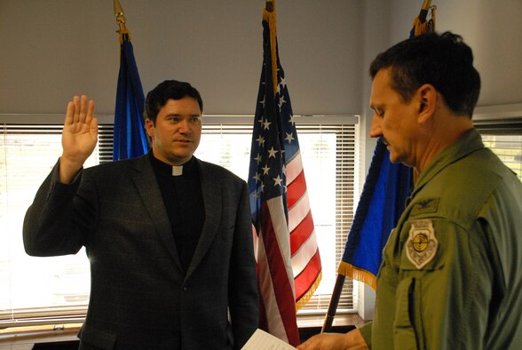 NIAGARA FALLS AIR RESERVE STATION, N.Y. - 914th Airlift Wing commander Colonel Reinhard Schmidt reads Capt. John R. Bastian his oath of office during a ceremony in the commander's office.  Before Capt. Bastian took his position here, he worked in a catholic seminary for the Army and has served the Catholic Church as an ordained priest for 13 years before deciding to receive a commission in the Air Force Reserve.  (U.S. Air Force photo / Airman 1st Class Andrew Caya)