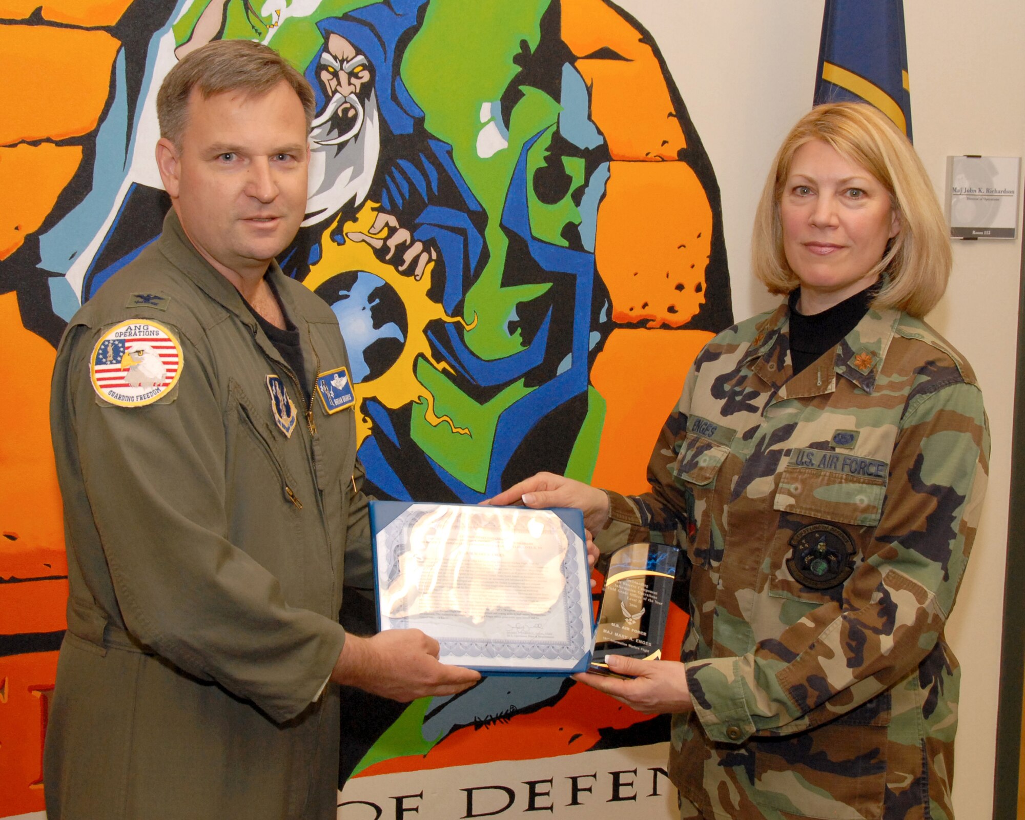SALT LAKE CITY - Maj. Mary Enges of the 101st Information Warfare Flight is presented the Outstanding Air Force Information Operations Award Air Reserve Component Field Grade Officer of the Year, Level II by Col. Brian Dravis, deputy director of operations at the National Guard Bureau in Washington, D.C. during the June 2007 UTA drill. (USAF photo by Tech. Sgt. Mike Evans)