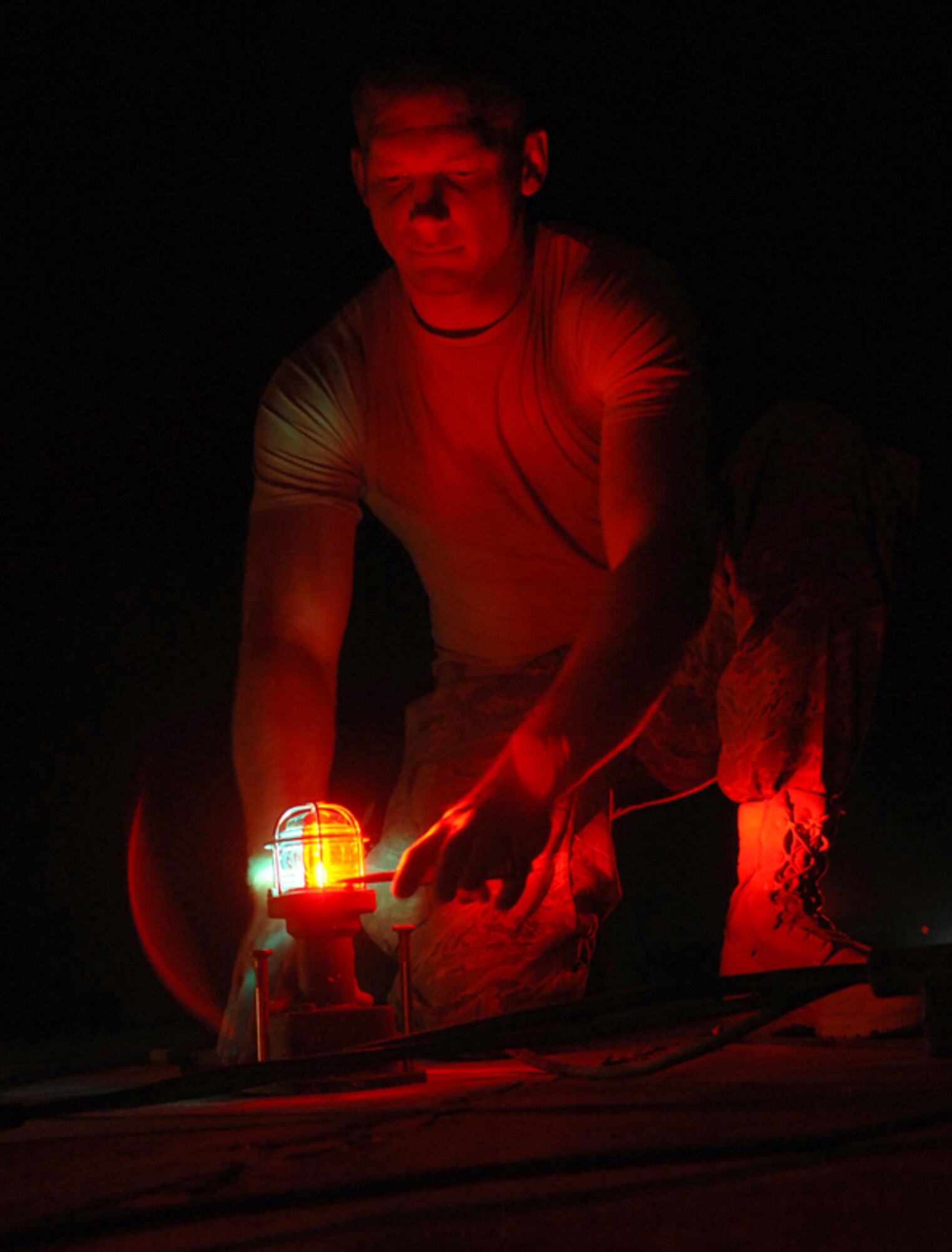 KIRKUK REGIONAL AIR BASE, Iraq -- Senior Airman Mitchell Robinson tests the runway lights at Kirkuk Regional Air Base, Iraq, Aug. 1.  Airman Robinson, an electrician with the 506th Expeditionary Civil Engineer Squadron here, is one of ten electricians deployed here who handle approximately 55 job orders each week around the installation. Airman Robinson is deployed from F.E. Warren Air Force Base, Wyo., and calls Marshall, Mich., home. (U.S. Air Fore photo/Senior Airman Randi Flaugh)