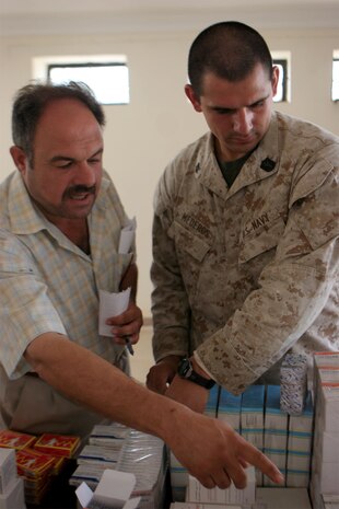 JAZEERA, Iraq (August 3, 2008) – Petty Officer Second Class Alberto Mederos, a corpsman with Task Force 1st Battalion, 2nd Marine Regiment, Regimental Combat Team 1, works with an Iraqi doctor handing out medicine during a Combined Medical Engagement at the al Rashid school, Aug. 3. Iraqi doctors and their assistants, with the support of Navy doctors and hospital corpsmen, provided much needed service to the Jazeera community. (Official U.S. Marine Corps photo by: Lance Cpl. Scott Schmidt) (RELEASED)