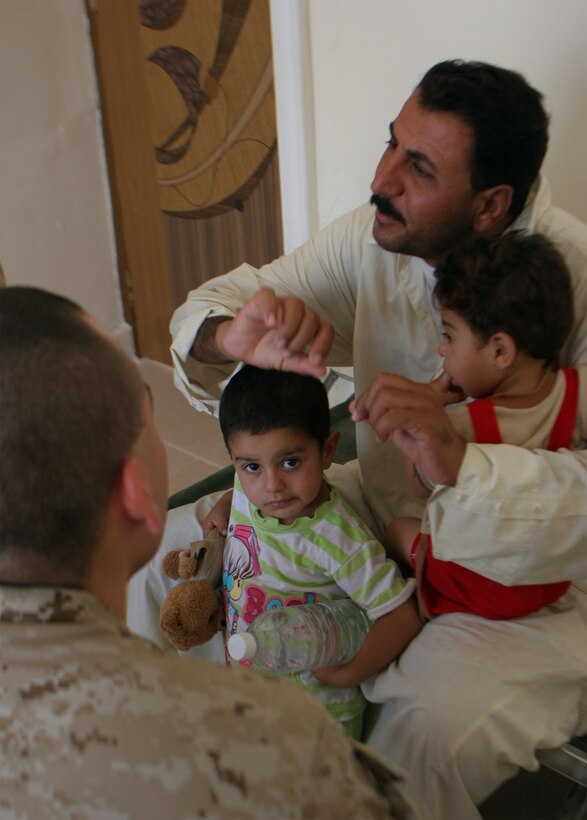 JAZEERA, Iraq (August 3, 2008) – An Iraqi father describes his child’s illness to a Navy doctor with Task Force 1st Battalion, 2nd Marine Regiment, Regimental Combat Team 1, during a Combined Medical Engagement at the al Rashid school, Aug. 3. Iraqi doctors and their assistants, with the support of Navy doctors and hospital corpsmen, provided much needed service to the Jazeera community. (Official U.S. Marine Corps photo by: Lance Cpl. Scott Schmidt) (RELEASED)