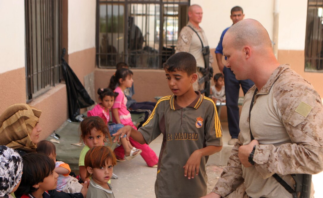 JAZEERA, Iraq (August 3, 2008) – Captain Thomas Schwabenbauer, a platoon commander with Company C, Task Force 1st Battalion, 2nd Marine Regiment, Regimental Combat Team 1, greets an Iraqi boy and his family during a Combined Medical Engagement at the al Rashid school, Aug. 3. In addition to providing medical care and security, the Marines and Iraqi Army and Police passed out toys and games to children, and set up a food collection point in the school yard. (Official U.S. Marine Corps photo by: Lance Cpl. Scott Schmidt) (RELEASED)
