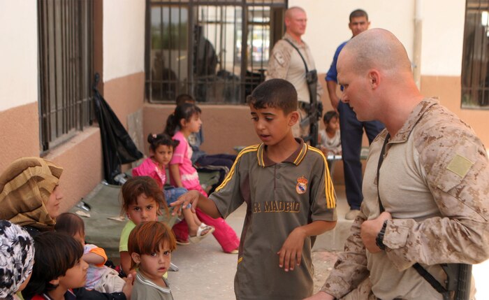 JAZEERA, Iraq (August 3, 2008) – Captain Thomas Schwabenbauer, a platoon commander with Company C, Task Force 1st Battalion, 2nd Marine Regiment, Regimental Combat Team 1, greets an Iraqi boy and his family during a Combined Medical Engagement at the al Rashid school, Aug. 3. In addition to providing medical care and security, the Marines and Iraqi Army and Police passed out toys and games to children, and set up a food collection point in the school yard. (Official U.S. Marine Corps photo by: Lance Cpl. Scott Schmidt) (RELEASED)