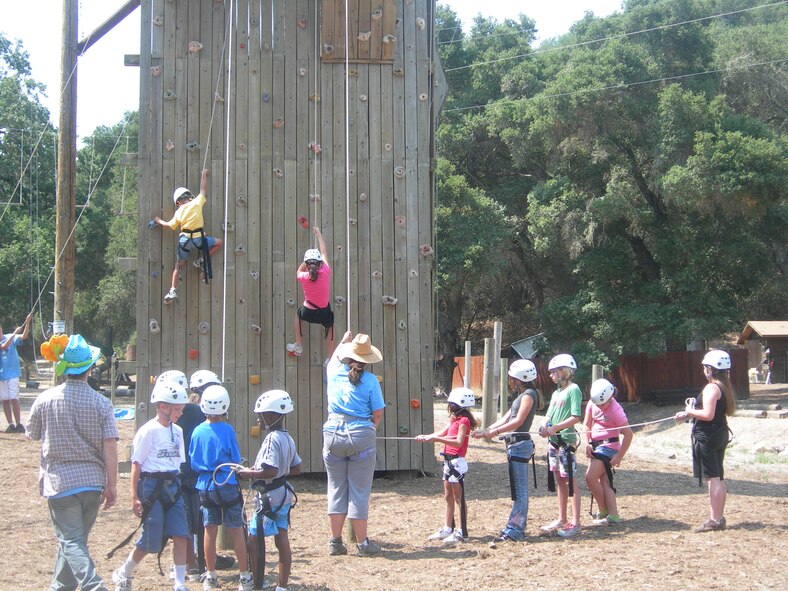 CAMP WHITTIER, Calif. --  Children climb a "rock wall" with the help of camp instructors at Operation Purple Camp here. OPC is a free, week-long camp open to children of military families. (Courtesy photo)