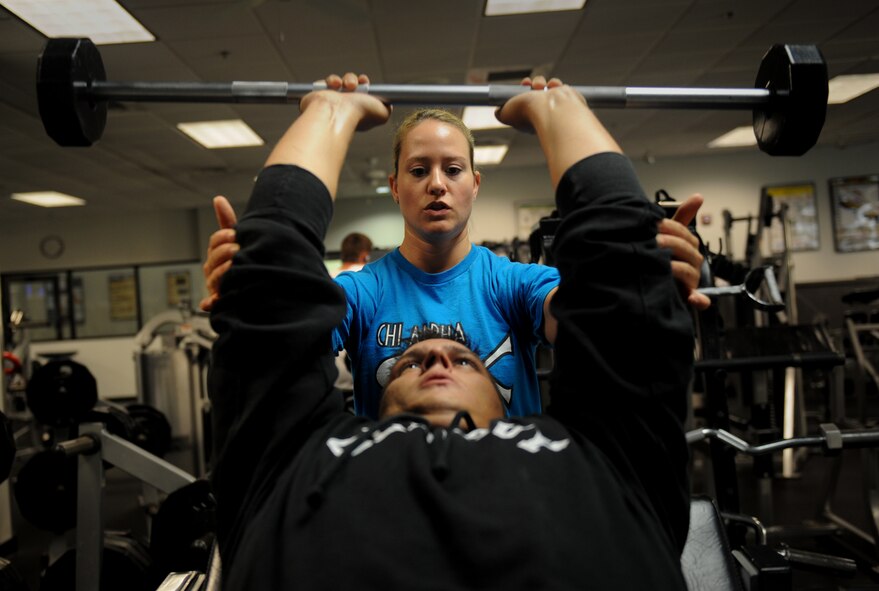 MOODY AIR FORCE BASE, Ga. -- Erin Carter, Chi Alpha Fitness physical trainer, instructs Tech. Sgt. Carl Anderson, 23rd Maintenance Operations Squadron quality assurance inspector, while lifting weights here July 31. There are currently six physical trainers available on base at the Freedom I fitness center. (U.S. Air Force photo by Senior Airman Gina Chiaverotti)
