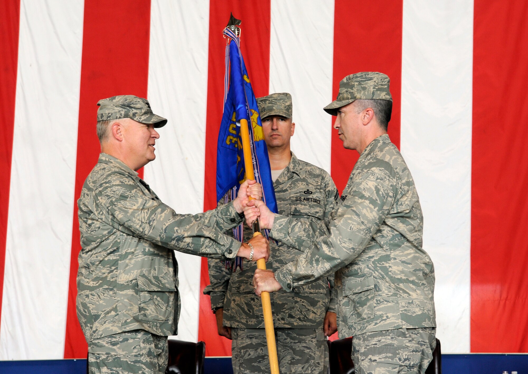 Left, Col. Jim Weber, 305th Maintenance Group commander, hands over the 605th Aircraft Maintenance Squadron guidon to Lt. Col. David Pastore, incoming 605th AMXS commander, at a change of command ceremony Aug. 1 here.  Lt. Col. Donald Atkinson relinquished command of the 605th AMXS to Colonel Pastore. (U.S. Air Force photo/Kenn Mann)