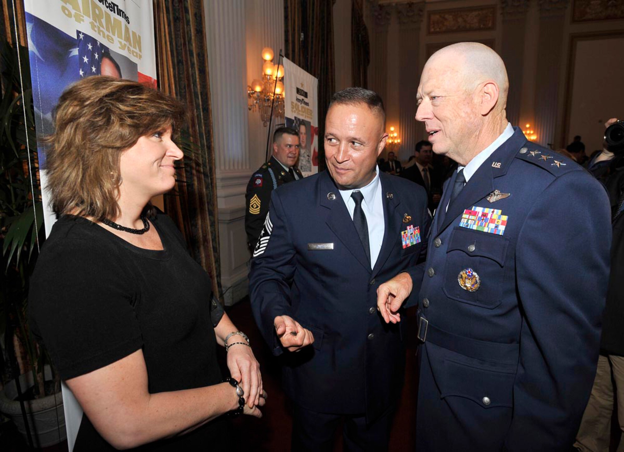 Chief Master Sgt. Stephen Page and his wife speak with Air Force Surgeon General Lt. Gen. Jim Roudebush at an awards reception July 30 in Washington, D.C. Chief Page was recognized as the Air Force Times newspaper's Airman of the Year. (U.S. Air Force photo/Scott M. Ash)