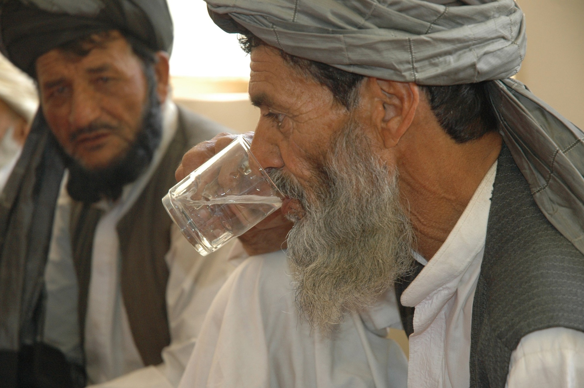 A Shajoy village elder sips purified water after Zabul Provincial Reconstruction Team medics introduced a new water sanitation process July 31 in the Shajoy District of Afghanistan. The team chose Shajoy to test run the process, which (after initial costs) creates clean drinking water for 300 families or approximately 5,000 people at just $5 per month. (U.S. Air Force photo/Capt. Jean Duggan) 

