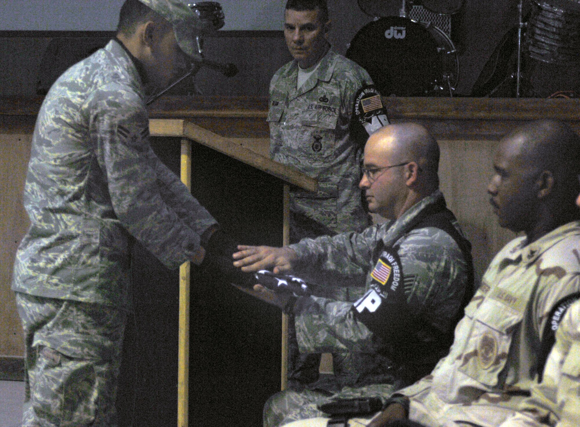 An honor guard member presents Staff Sgt. Sean Neisen with an American flag in honor of Goro, a military working dog, during a memorial ceremony Aug. 1 at Ali Base, Iraq. Sergeant Neisen, a K-9 handler, and Goro deployed from the 435th Security Forces Squadron from Ramstein Air Base, Germany, to the 407th Provost Marshal Office here. Goro died unexpectedly July 28 from natural causes. (U.S. Air Force photo/Tech. Sgt. Francesca Popp) 

